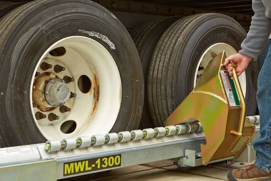 Manual wheel lock securing trailer wheel at loading dock